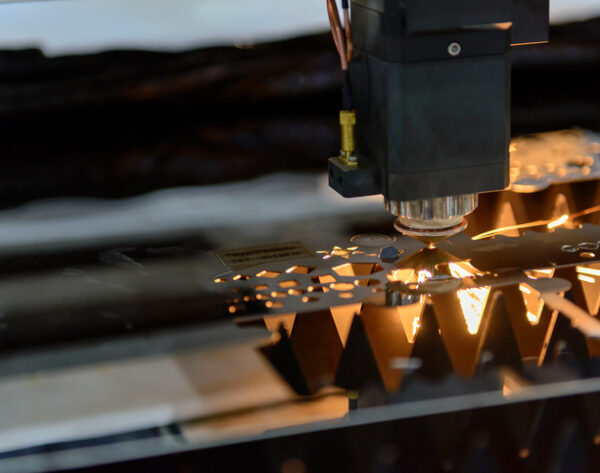 Close-up of the laser cutting machine cutting the stainless plate.